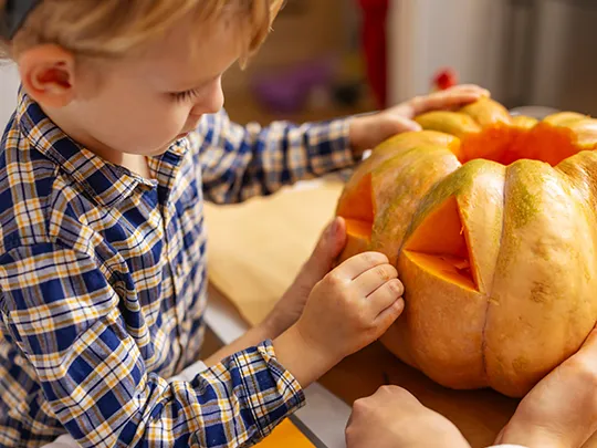 Child carving a Pumpkin